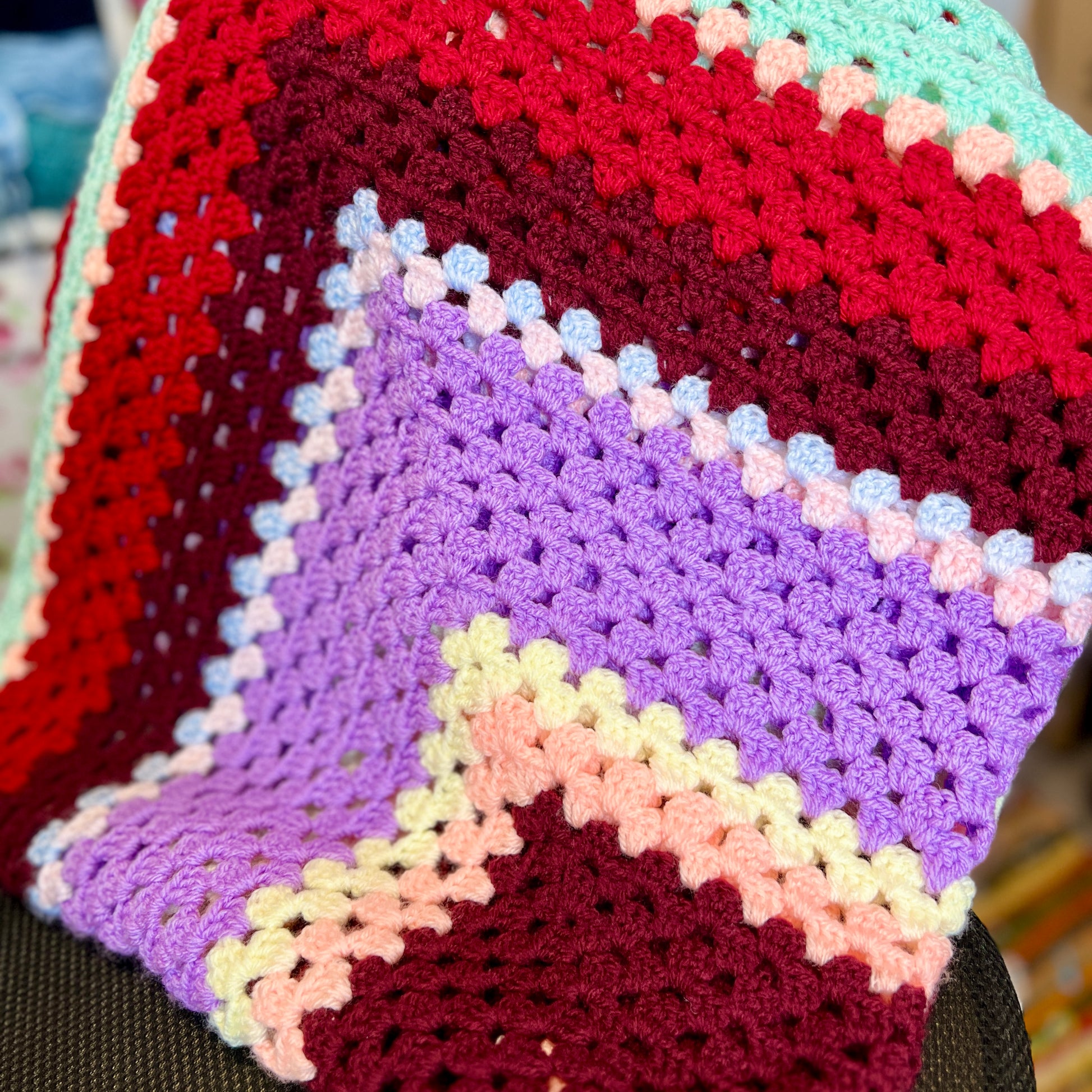 Colorful crocheted blanket with a gradient pattern.
