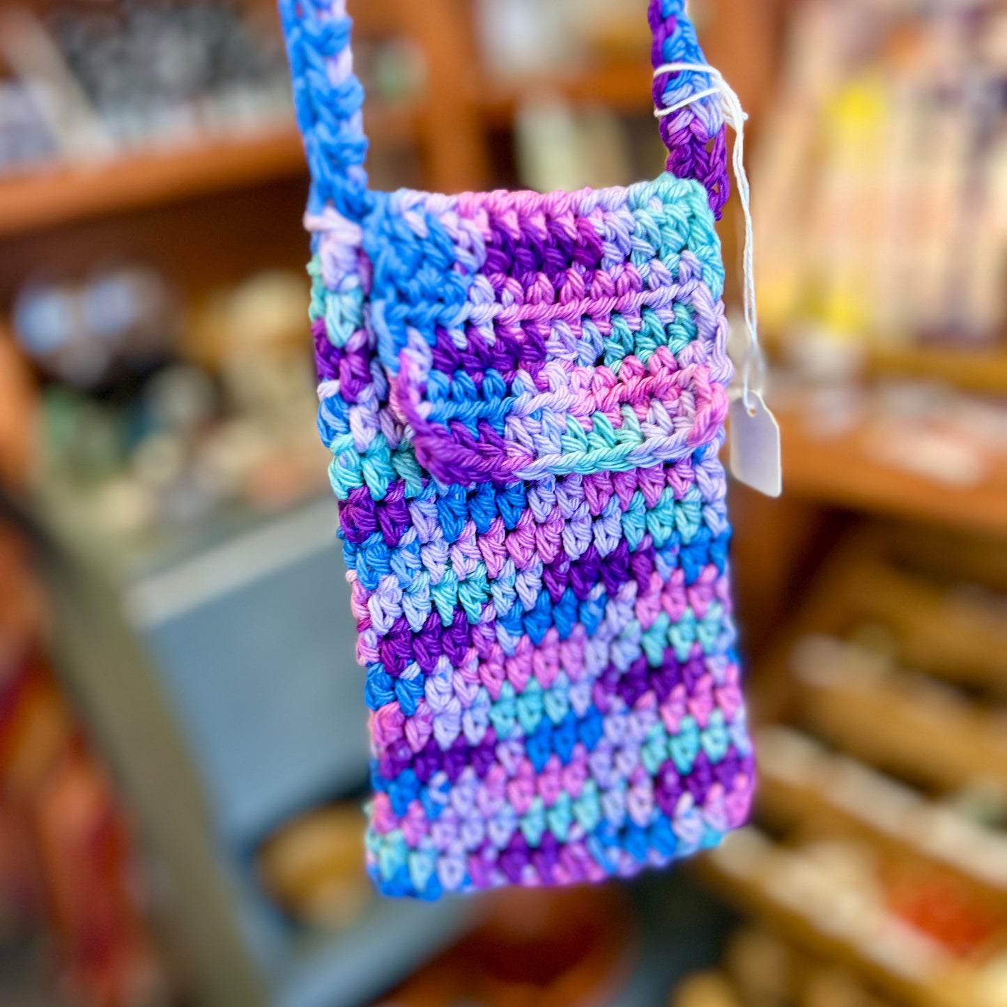 Crocheted pouch with a tag in a store setting